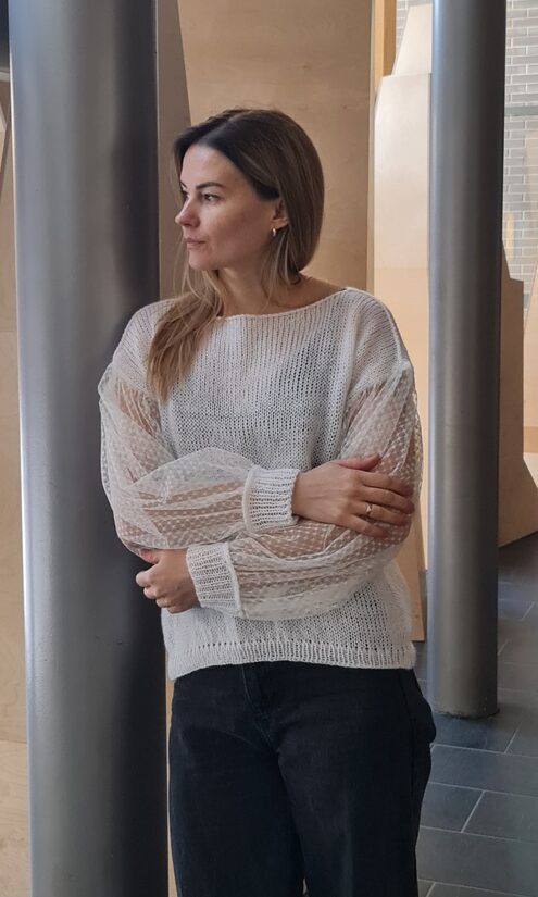 Balts džemperis ar tilla piedurknēm.