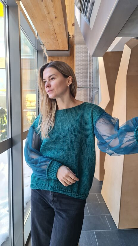 Smaragdzaļš džemperis ar tilla piedurknēm.